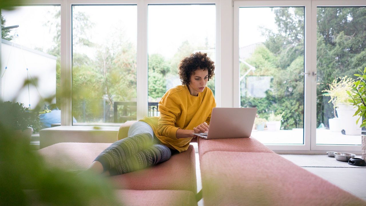 Woman in yellow jumper at laptop