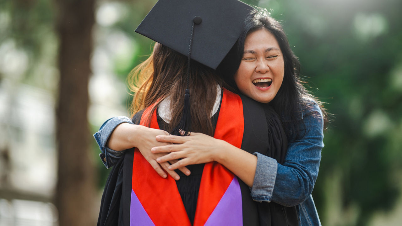 Woman hugging graduating student